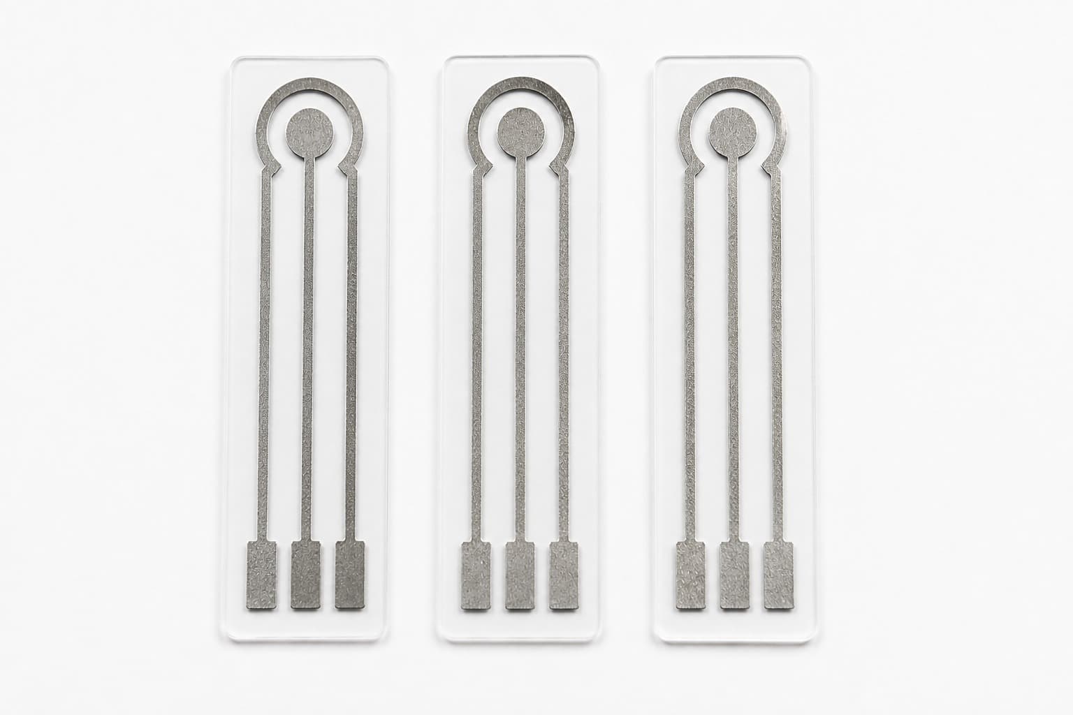 Three silver printed electrochemical sensors arranged vertically on a white background
